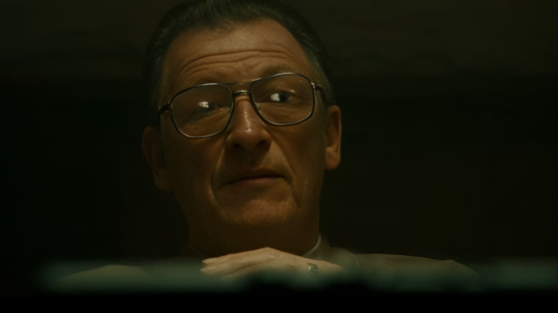 Behind glasses and shadows, Richie weighs the next bloody move, cool and calculated in his strategy. (Image via Paramount)